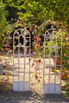 Arch for a wedding ceremony on the street .The decor is decorated with arches in the form of doors with fresh flowers.