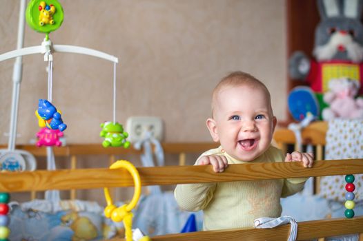 Close-up portrait of a lonely baby smiling in bed. The concept of the child.