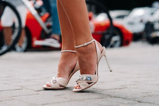 a woman in high-heeled shoes with artificial diamonds in the city. Beautiful feet in shoes close-up