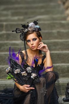 Beautiful stylish bride in a black dress sits on the stairs in Florence, Italy.