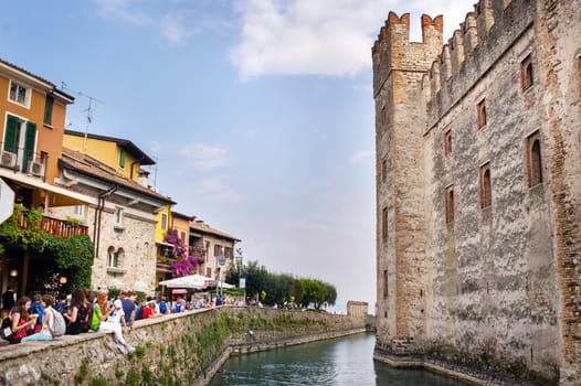 Sirmione, Italy-October 9, 2018: People relax in the town of Sirmione near the castle of Scaligera.