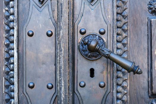 Old metal door handle on the old door.