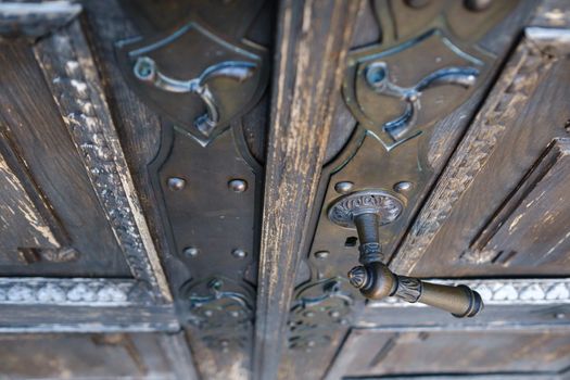 Old metal door handle on the old door.
