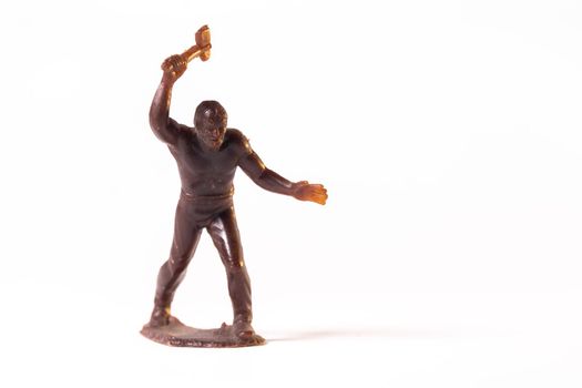 Large toy figures of primitive people on a white background.