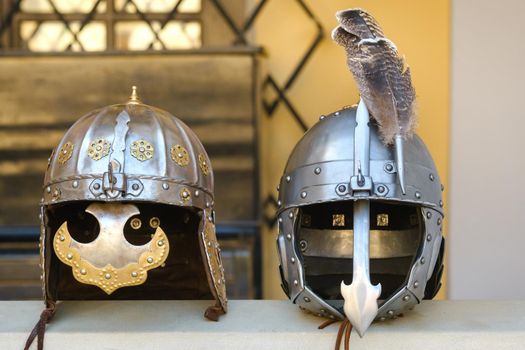 Two knight's helmets are lying on the surface.Medieval concept.