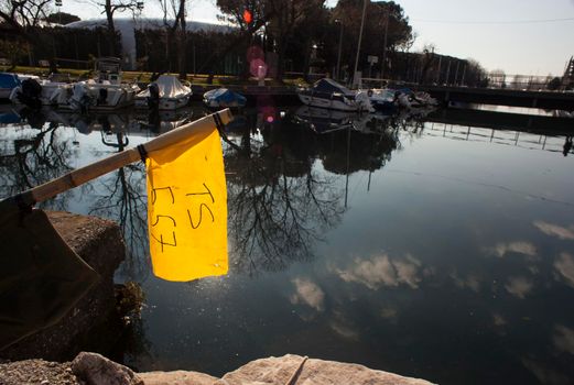 Yellow flag of a boat, Villaggio del Pescatore. Italy