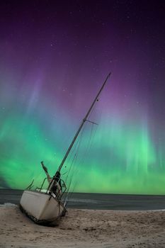 Aurora borealis over a shipwreck off the coast of Uttakleiv Beach in Norway