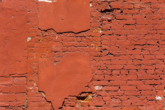 old brick wall with peeled off plaster, all over painted orange - full frame background and texture