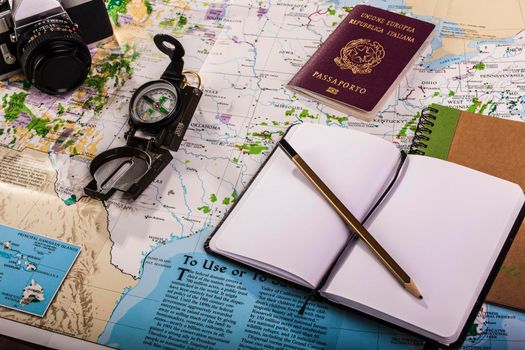 Travel planning. Compass, passport, photo camera and block notes on map