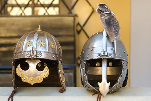 Two knight's helmets are lying on the surface.Medieval concept.