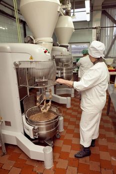 The process of making cookie dough in an industrial kneading machine at the factory.