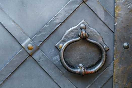 Old metal door handle on the old door.