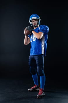 Portrait of a man in a blue uniform for american football on a black background