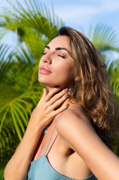 Outdoor portrait of beautiful woman in green summer dress on tropical background, sensual, romantic, warm sunset light