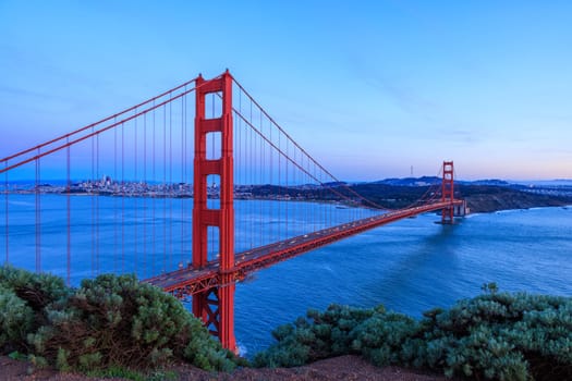 Iconic Golden Gate Bridge and San Francisco city on coast at sunset. High quality photo