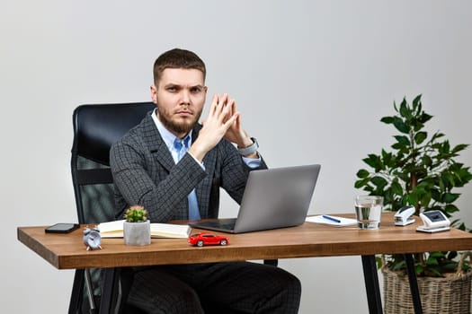 young man sitting on chair at table and resting, using laptop