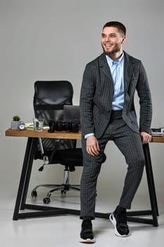 Professional male photographer smiling cheerfully while working at her desk.