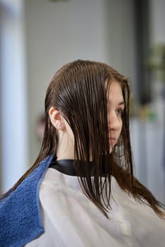 young girl gets fashionable haircut in modern hairdressing salon