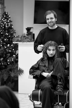 Beautiful young woman in modern hair salon. hairdresser checking hairstyle of caucasian girl