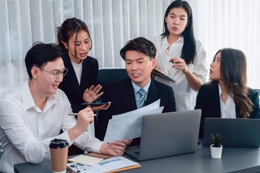 Harmony in office concept as business people analyzing dashboard paper together in workplace. Young colleagues give ideas at manager desk for discussion or strategy planning about project.