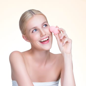 Closeup personable beautiful natural soft makeup woman using powder puff for facial makeup concept. Cushion foundation applying on young girl face in isolated background.