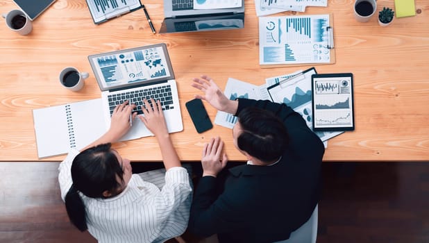 Top-view business team of financial data analysis meeting with business intelligence, report paper and dashboard on laptop for marketing strategy. Business people working together in office of harmony