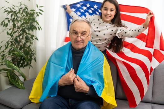 grandfather and granddaughter with the flags of the USA and Ukraine.