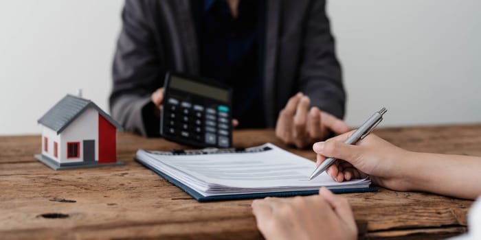 Sealing a deal. Asian people business real estate agent with client consulting and discussing at office desk. talking with contract agreement before signing. Sign a contract..