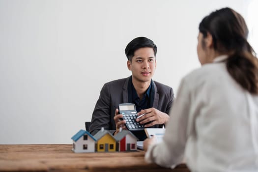 Sealing a deal. Asian people business real estate agent with client consulting and discussing at office desk. talking with contract agreement before signing...