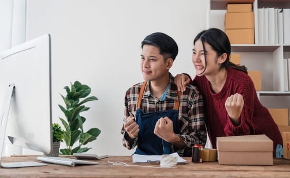 Young asian people couple Male and female small business owner checking online orders and packing the product together