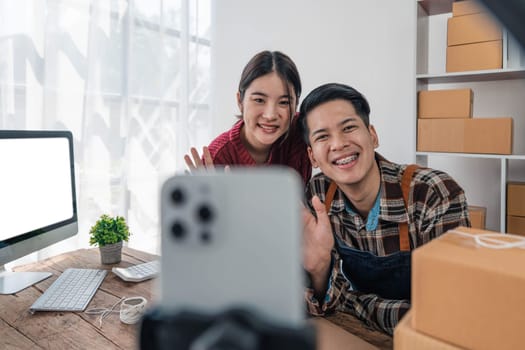 Young asian people couple Male and female small business owner checking online orders and packing the product together