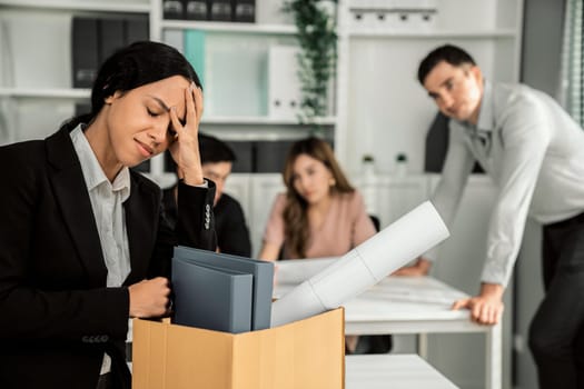 Depressed and disappointed employee packing her belongings after being fired for not being competent. Gossiped by her colleagues behind his back. Layoff due to economic depression.