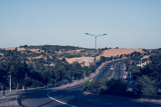 Highway curve road overpass nature landscape background dark tone mist day time street tall lanterns trees bushes sideway.