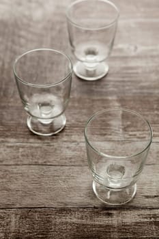 Three empty glasses lying on wooden table. Studio photo