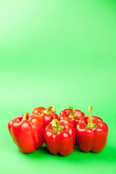 Group of five fresh and healthy sweet red pepperson green background