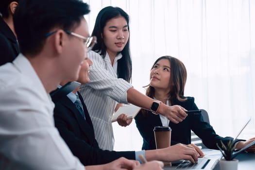 Harmony in office concept as business people analyzing dashboard paper together in workplace. Young colleagues give ideas at manager desk for discussion or strategy planning about project.