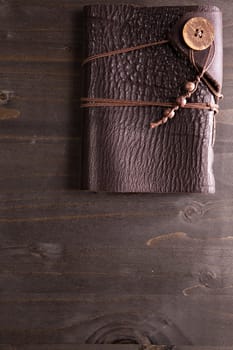 Over top view of Vintage notebook with leather cover on wooden backgorund