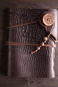 Top view of vintage notebook with leather cover on wooden backgorund