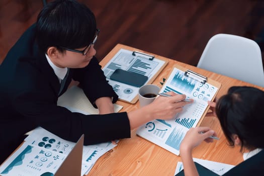 Top-view business team of financial data analysis meeting with business intelligence, report paper and dashboard on laptop for marketing strategy. Business people working together in office of harmony