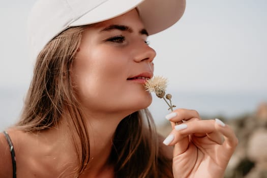 Woman travel sea. Happy tourist taking picture outdoors for memories. Woman traveler looks at the edge of the cliff on the sea bay of mountains, sharing travel adventure journey.