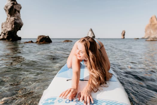 Close up shot of happy young caucasian woman looking at camera and smiling. Cute woman portrait in bikini posing on a volcanic rock high above the sea