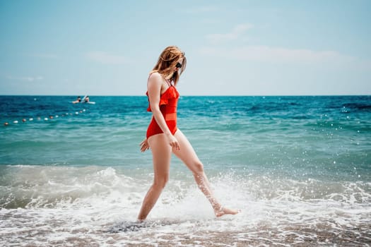 Pretty young blonde woman walking on the beach in summer, having fun, walks carefree on the seaside . Portrait beautiful young woman relax smile around beach sea ocean in holiday vacation travel trip.