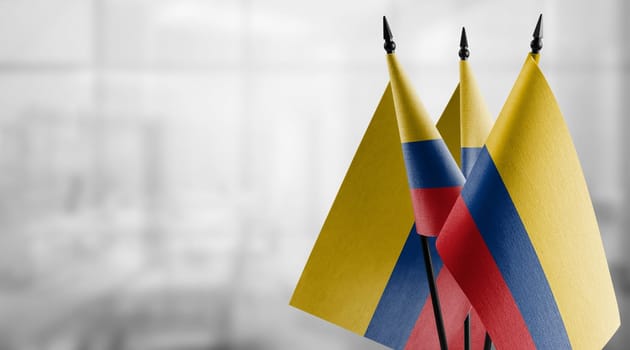 Small flags of the Colombia on an abstract blurry background.