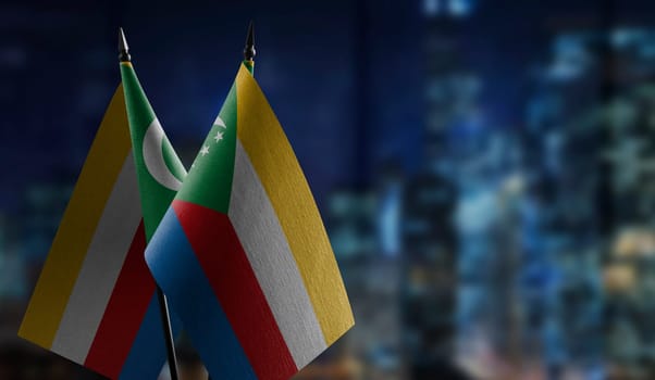 Small flags of the Comoros on an abstract blurry background.
