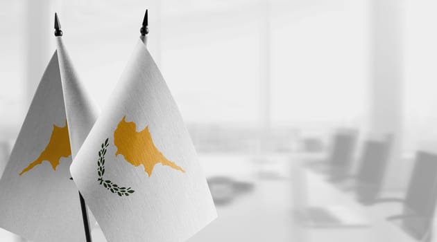 Small flags of the Cyprus on an abstract blurry background.