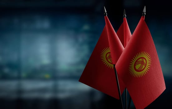 Small flags of the Kirghizia on an abstract blurry background.