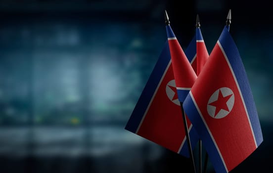 Small flags of the North Korea on an abstract blurry background.
