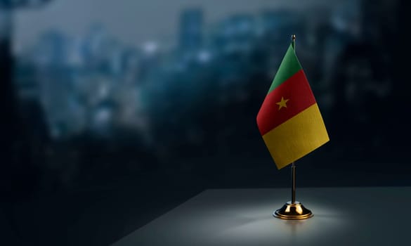Small flags of the Cameroon on an abstract blurry background.