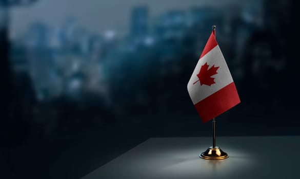 Small flags of the Canada on an abstract blurry background.