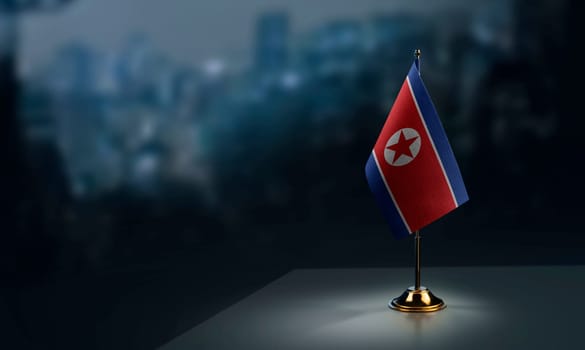 Small flags of the North Korea on an abstract blurry background.